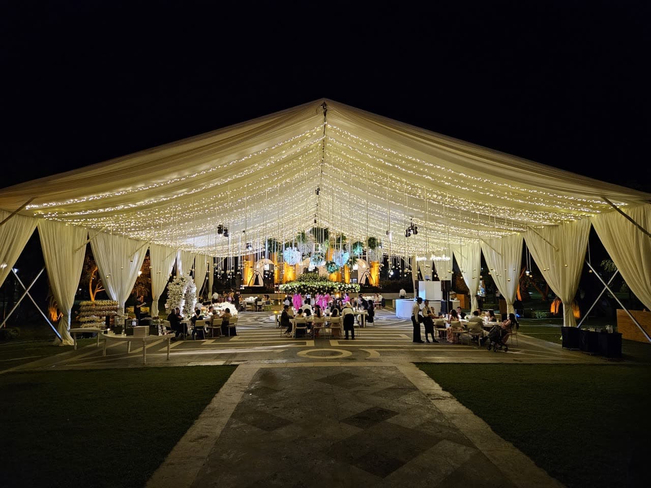 Carpa de evento brillando de noche con iluminación cálida interior