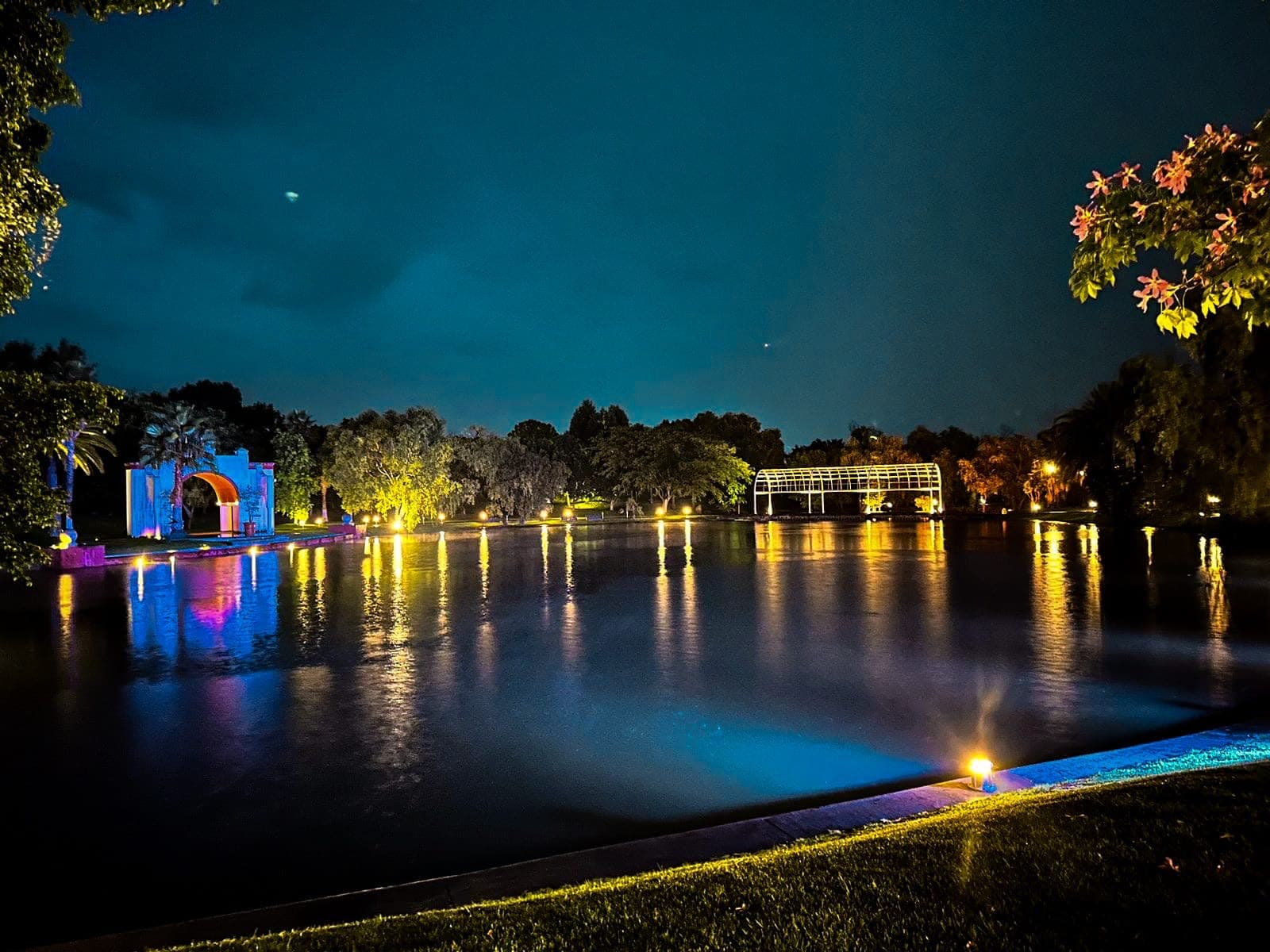 Lago iluminado de noche con reflejos azules en evento privado