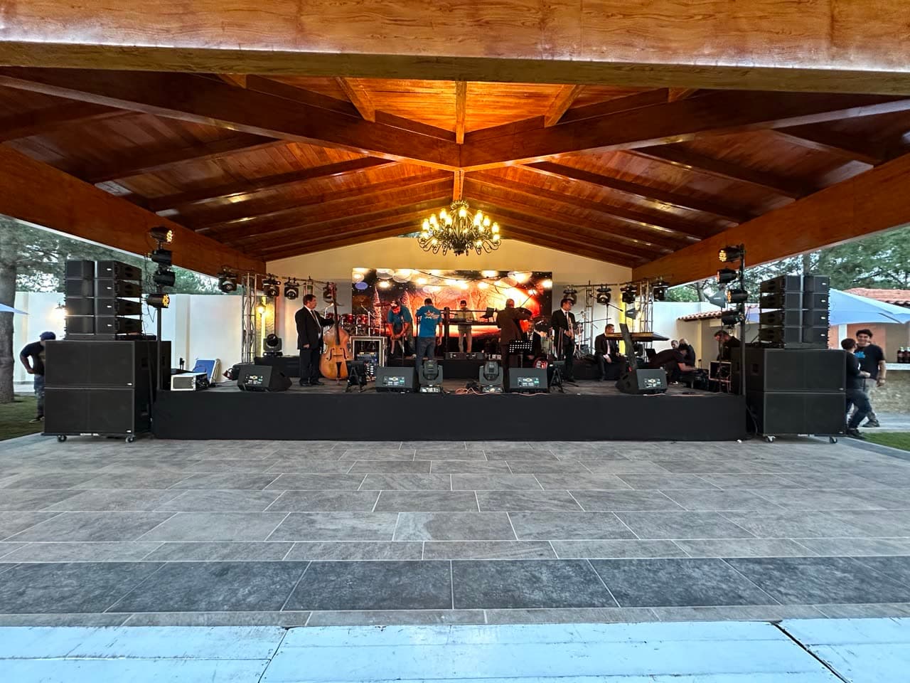Sistema de audio line array montado en salón de eventos con candil