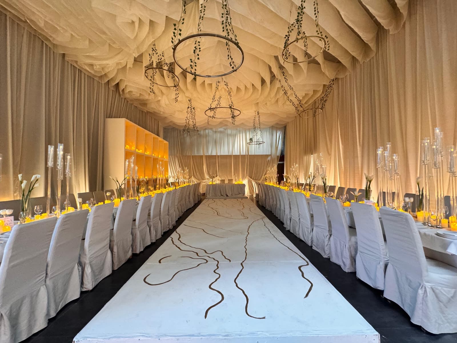 Pista de baile blanca con caligrafía pintada a mano entre mesas imperiales en boda elegante