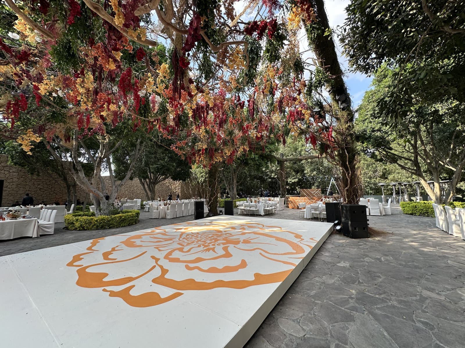 Pista de baile personalizada pintada a mano con flor de cempasúchil en jardín de eventos